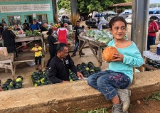 Young Alesha Muhuinga sips the juice of a fresh green coconut at the Saturday Market in the Port of Refuge, Tonga