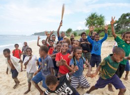 Schoolboys burning off energy on the beach in Tanna welcome the crew of Flying Fish